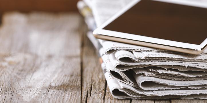 Des journaux et une tablette sur une table